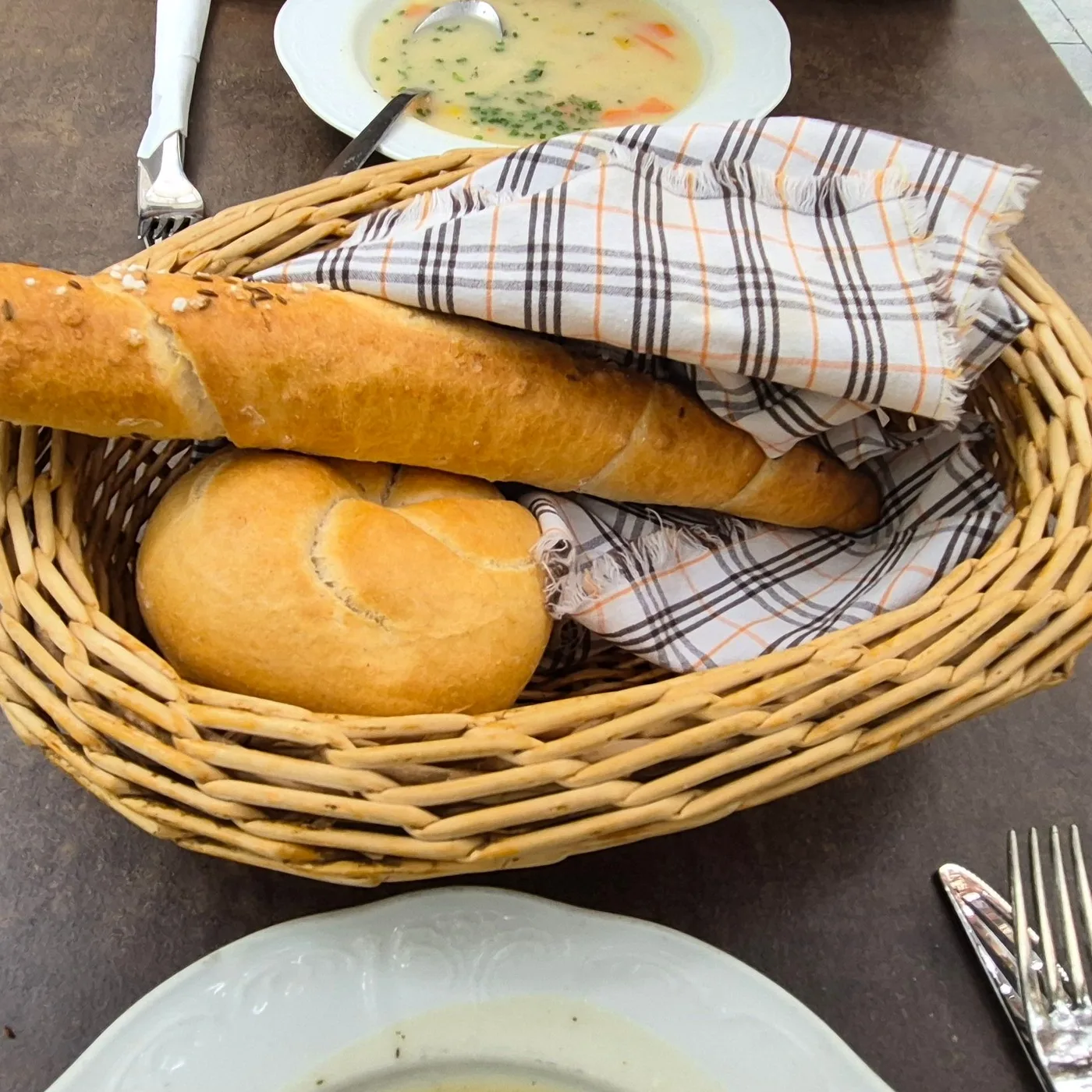 Brotkorb mit Salzstangerl und Semmel, fotografiert von einem Gast